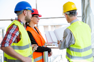 3 tradies looking at paperwork on a construction site