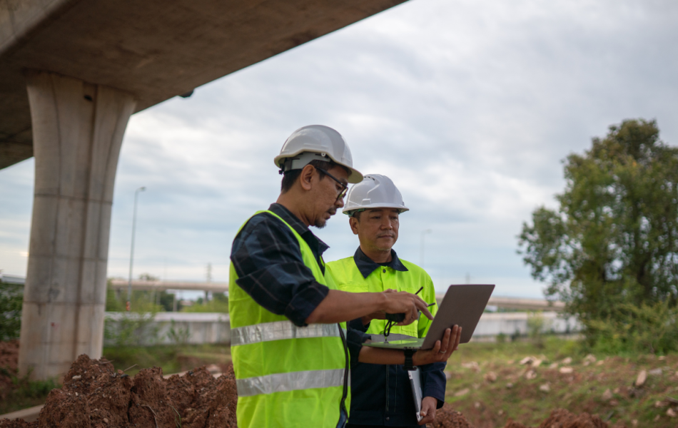 construction safety workers discussing compliance documents on a computer