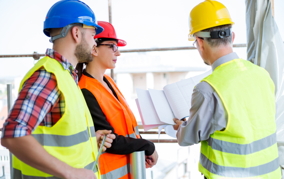 3 tradies looking at paperwork on a construction site